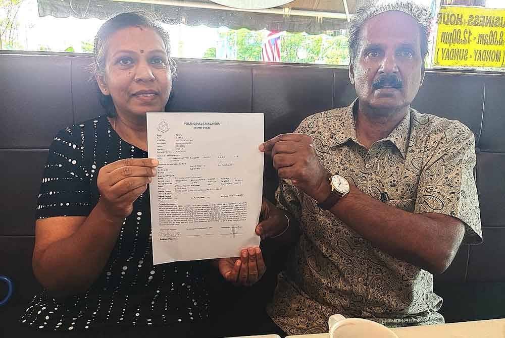 Manickam (kanan) menunjukkan laporan polis dibuat bagi mengesan siasatan lanjut dibuat polis.