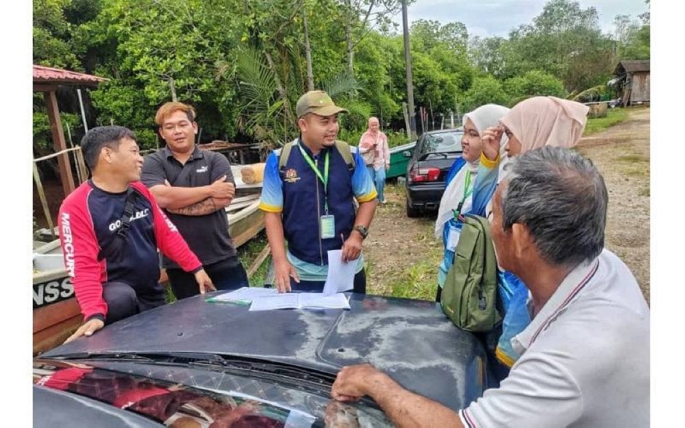 Pegawai Jabatan Perikanan memberi maklumat kepada beberapa orang nelayan di Jeti Nelayan Bukit Palong, Port Dickson.