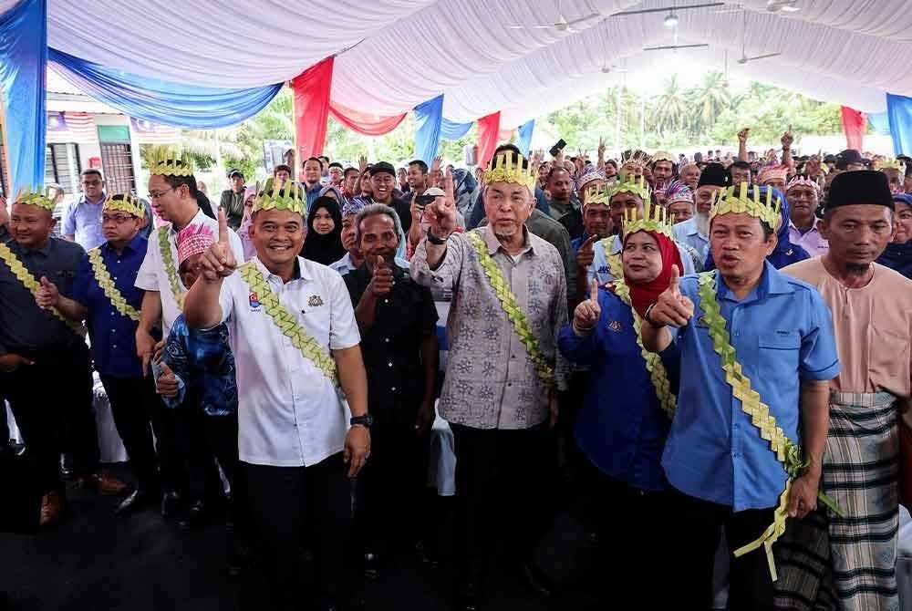 Ahmad Zahid (empat dari kanan) bersama Timbalan Menteri Kerja Raya Datuk Seri Ahmad Maslan (dua dari kanan) pada Program Tautan Kasih Bersama Masyarakat Orang Asli di Kampung Tanah Runtuh, di sini pada Khamis. Foto Bernama