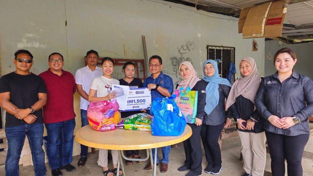 Timbalan Menteri Pendidikan Tinggi, Datuk Ts Mustapha Sakmud (tengah) bersama Pengarah Negeri, Pejabat PTPTN Negeri Sabah, Muliati Kamaruddin menyerahkan replika kad WPP kepada enam penerima secara walkabout di Parlimen Kota Belud, Sabah.