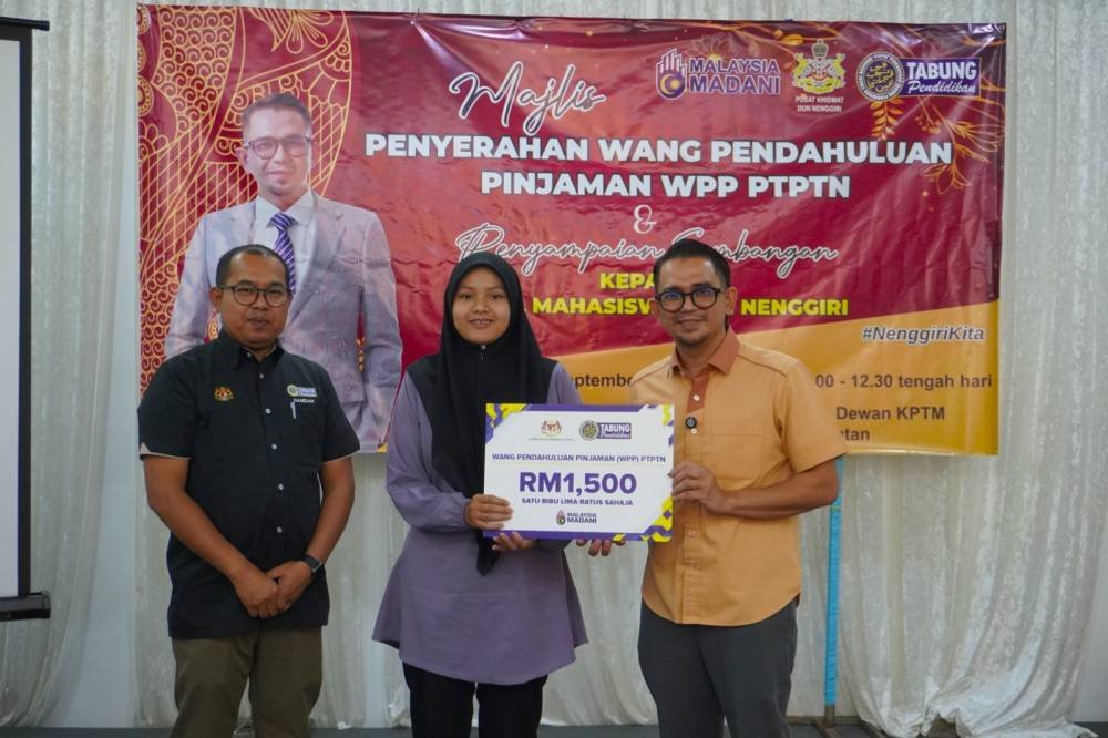 Pengarah Negeri, Pejabat PTPTN Negeri Kelantan, Hamdan Razali (kiri) dan Ahli Dewan Undangan Negeri (ADUN) Nenggiri, Mohd Azmawi Fikri Abdul Ghani (kanan) menyampaikan kad replika WPP kepada 36 penerima di Gua Musang, Kelantan.