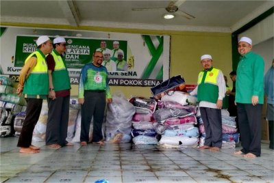 Ahmad (dua dari kanan) memeriksa sumbangan barangan untuk diagihkan kepada mangsa banjir.