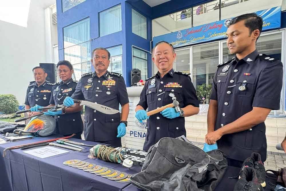Hamzah (tiga dari kanan) menunjukkan senjata dan barangan yang dirampas daripada suspek.
