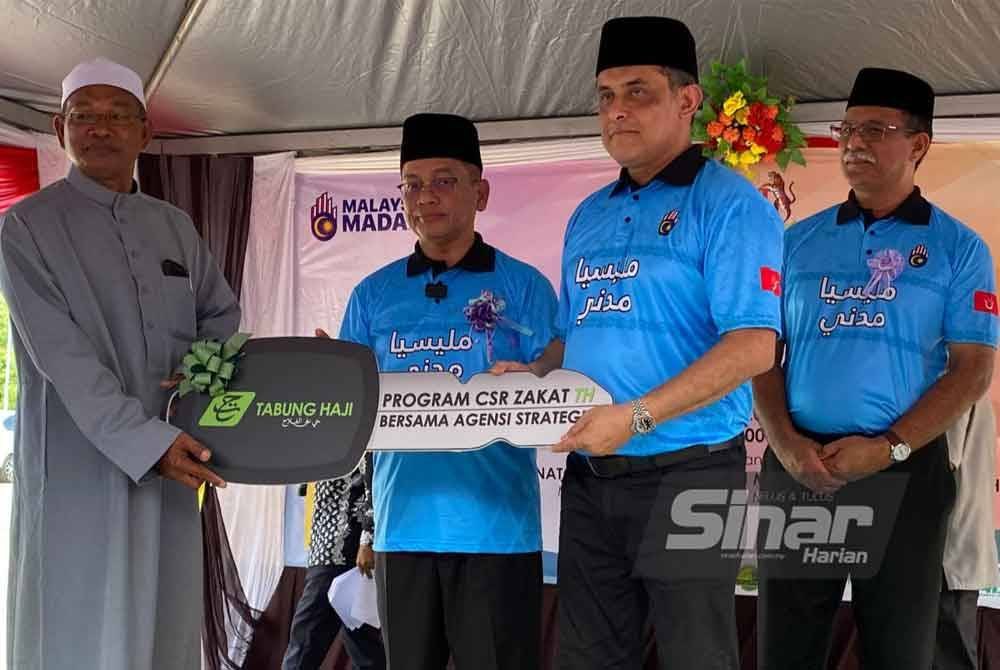 Mohd Na’im (tiga, kanan) menyampaikan replika kunci kepada wakil Masjid Saidina Umar Al-khattab Mukim Telekong di Kuala Krai.