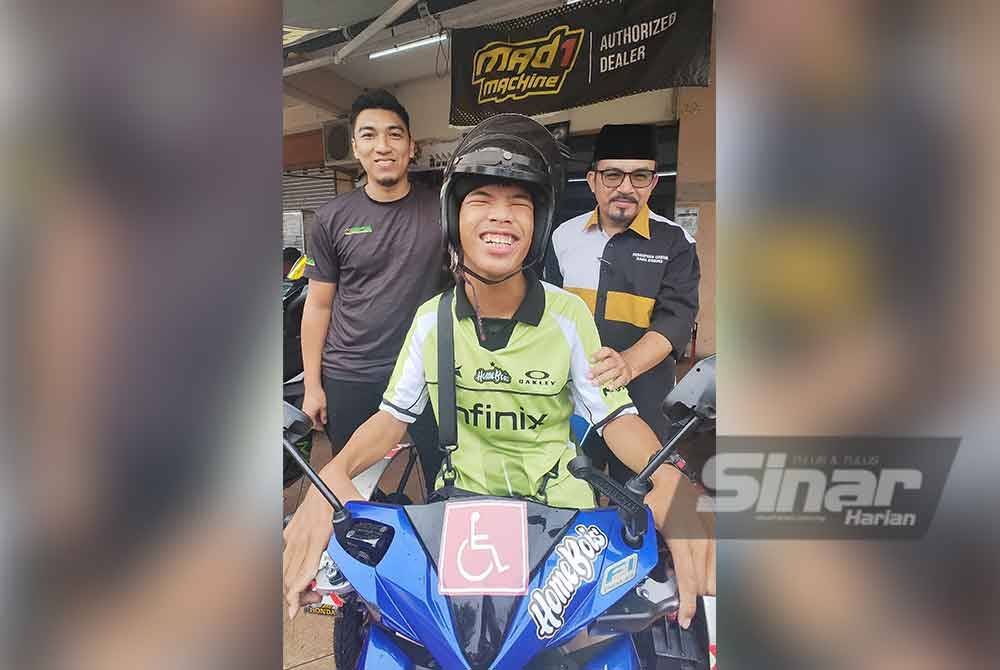 Aniq berterima kasih kepada Muhammad Amir (kiri) dan Zulkifli yang menawarkan servis motosikal percuma kepadanya.