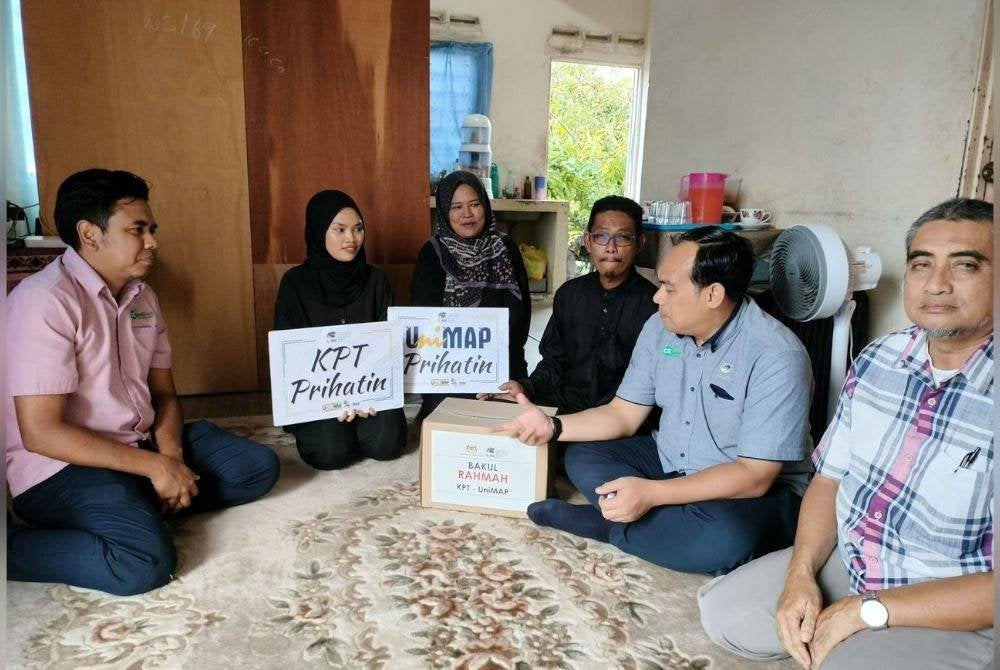 Mohd Mustafa (dua kanan) menyampaikan sumbangan awal kepada bakal pelajar UniMAP, Nur Hidayah Rohimi (dua kiri) dan keluarganya di Beseri Perlis.