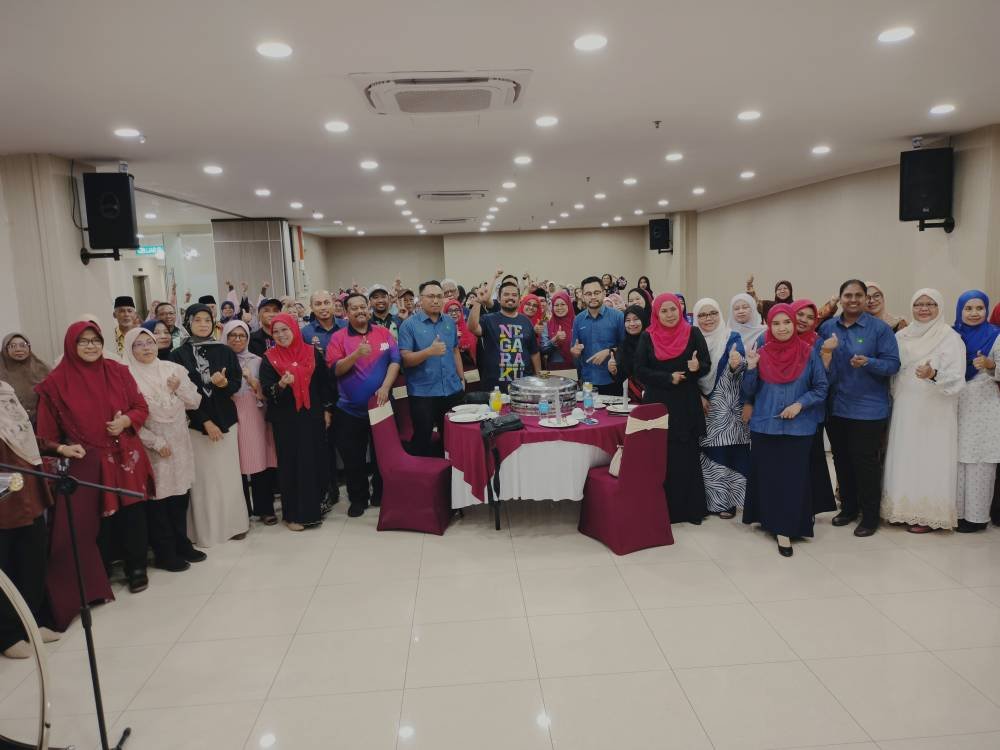 Manndzri (tengah) bergambar bersama pekebun RISDA pada program GKKG peringkat daerah Kluang di sebuah hotel pada Khamis.