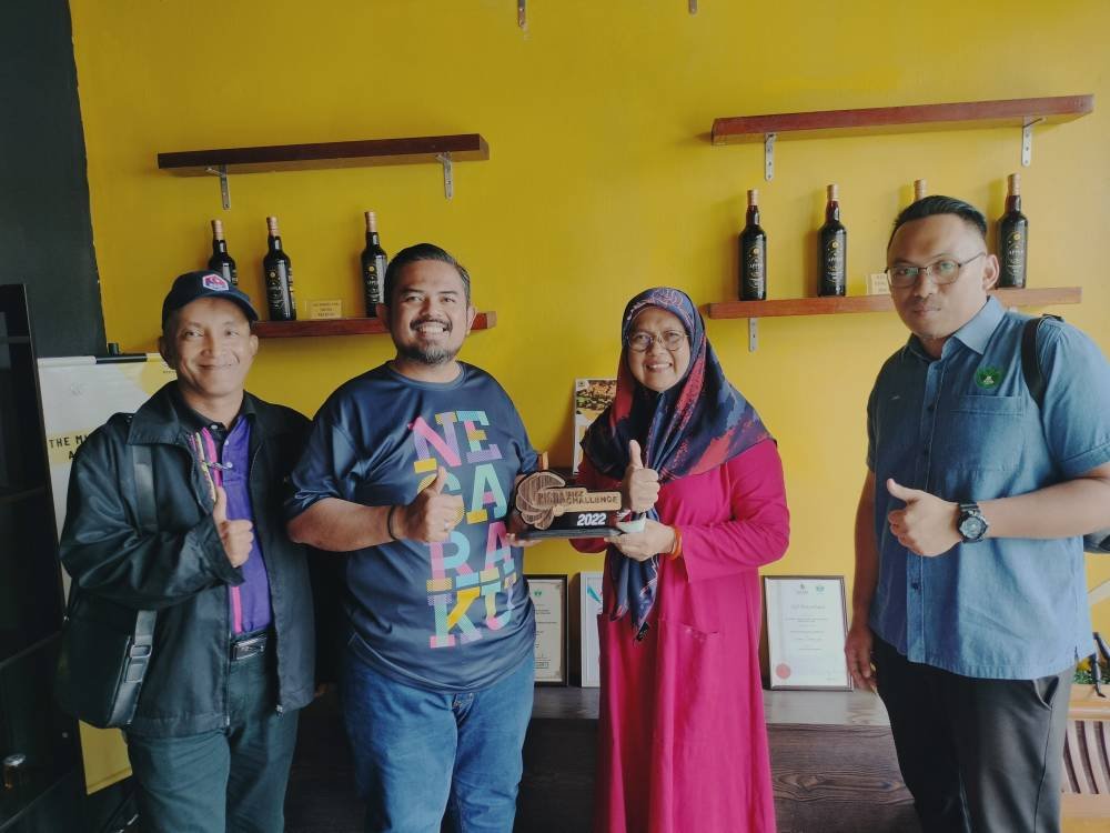 Manndzri (dua dari kiri) bergambar dengan Dayangku Puziah (tiga dari kiri) di bengkel pemprosesan jus madu epal di Taman Sri Intan Kluang.