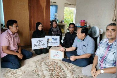 Mohd Mustafa (dua kanan) menyampaikan sumbangan awal kepada bakal pelajar UniMAP, Nur Hidayah Rohimi (dua kiri) dan keluarganya di Beseri Perlis.