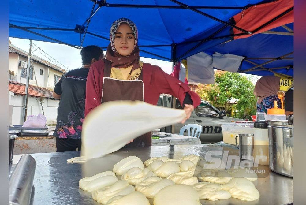 Nor Syazwani menunjukkan kemahirannya menebar roti canai digerai ‘Roti Canai Abah’ di Indera Mahkota Dua di sini, pada Jumaat.