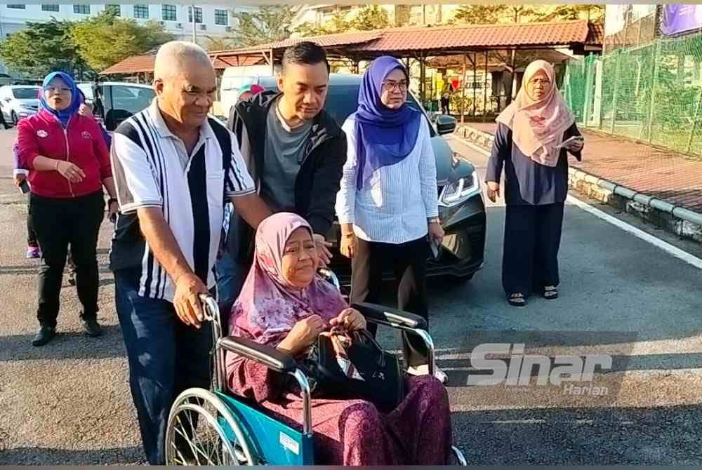 
Onn Hafiz memandu kenderaan untuk membawa pasangan warga Zuriah dan Abdul Aziz ke pusat pembuangan undi di SMK Seri Perdana.