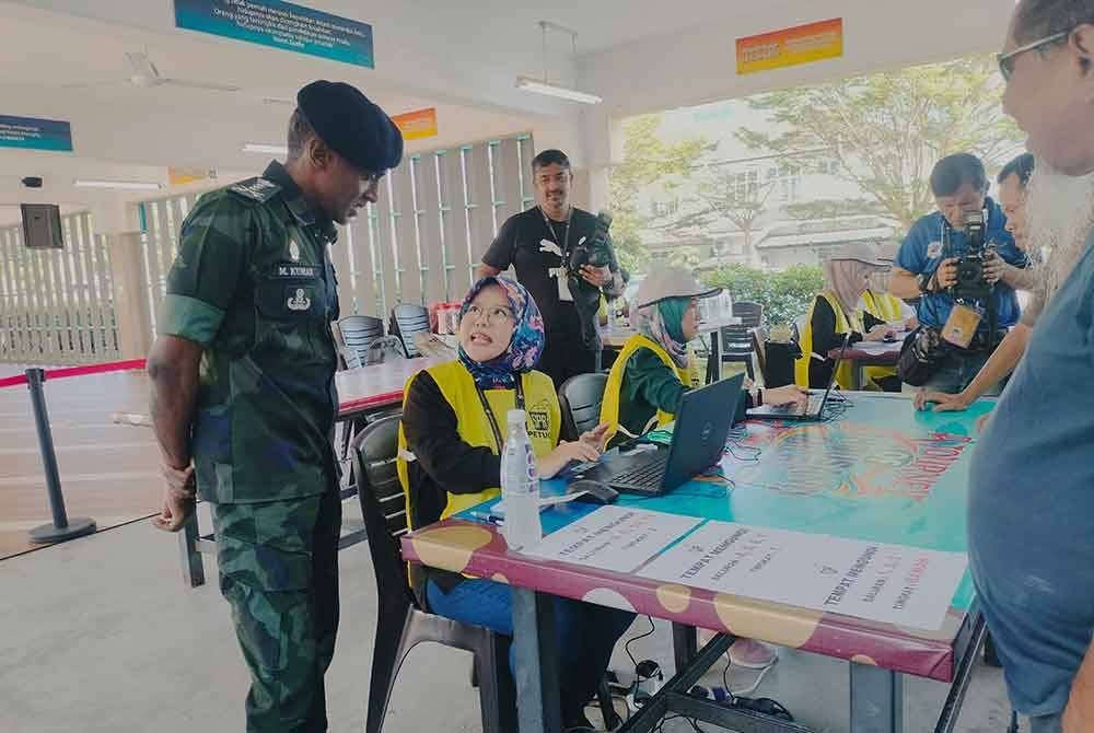 Kumar (kiri) meninjau proses pengundian di SMK Seri Perdana.