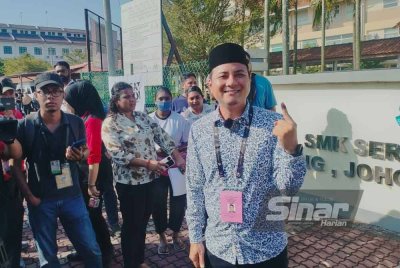 Syed Hussien (kanan) selesai membuang undi di SMK Seri Perdana.