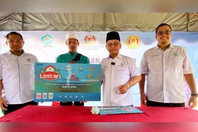 Mohd Na'im (dua, kanan) menyampaikan bantuan keusahawanan (YaPEIM) Niaga kepada penerima pada Program Sinar Lestari Yayasan Pembangunan Ekonomi Islam Malaysia (YaPEIM) di Kampung Pulau Pisang di Kota Bharu pada Sabtu.