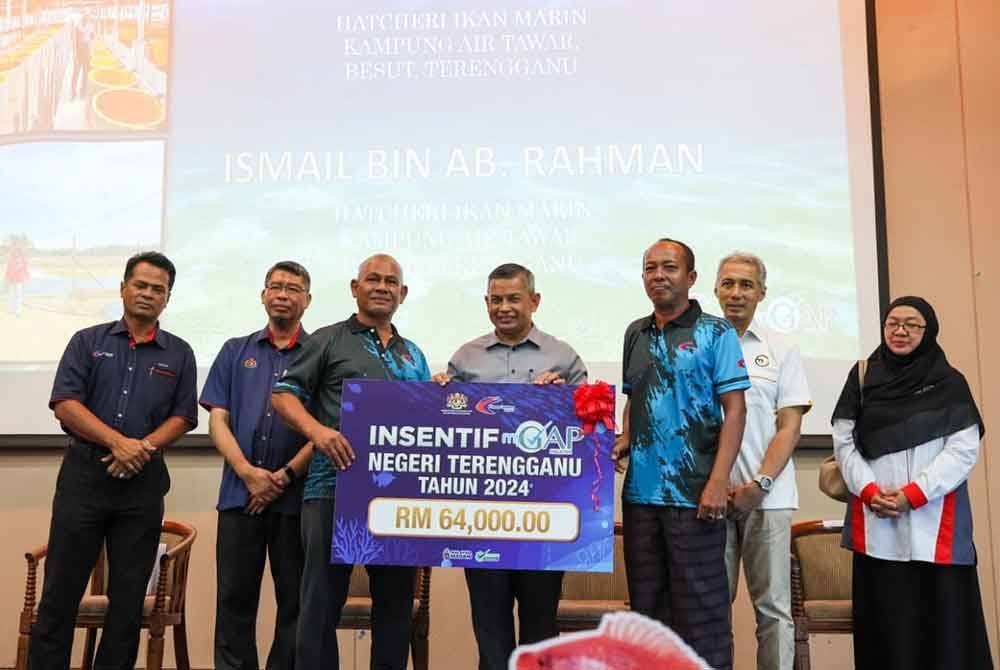 Azman (tengah) menyampaikan mock cheque insentif MyGAP bernilai RM64,000 kepada penternak.