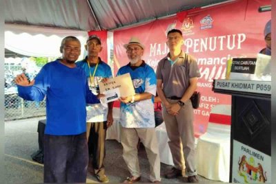 Syed Abu Hussin (dua dari kiri) menyampaikan hadiah kepada pemenang sempena Majlis Penutup Kejohanan Memancing Kelubong Challenge di Dewan Orang Ramai Kampung Kelubong pada Sabtu.