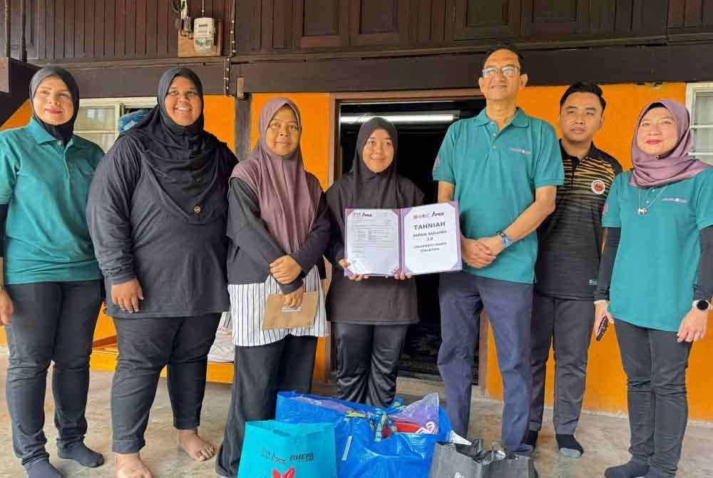 Selain wang tunai, USM juga menyerahkan bantuan barang keperluan yang disampaikan Abdul Rahman (tiga dari kanan) kepada Syaidinatul.