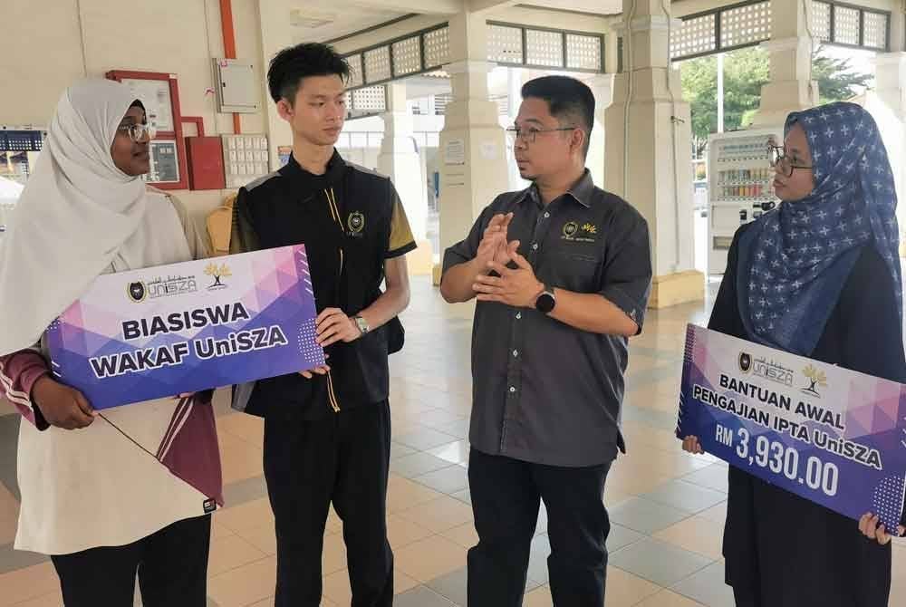 Dr. Ahmad Faizol (dua dari kanan) memberikan penerangan mengenai Biasiswa Wakaf UniSZA kepada pelajar yang menerima bantuan biasiswa tersebut.