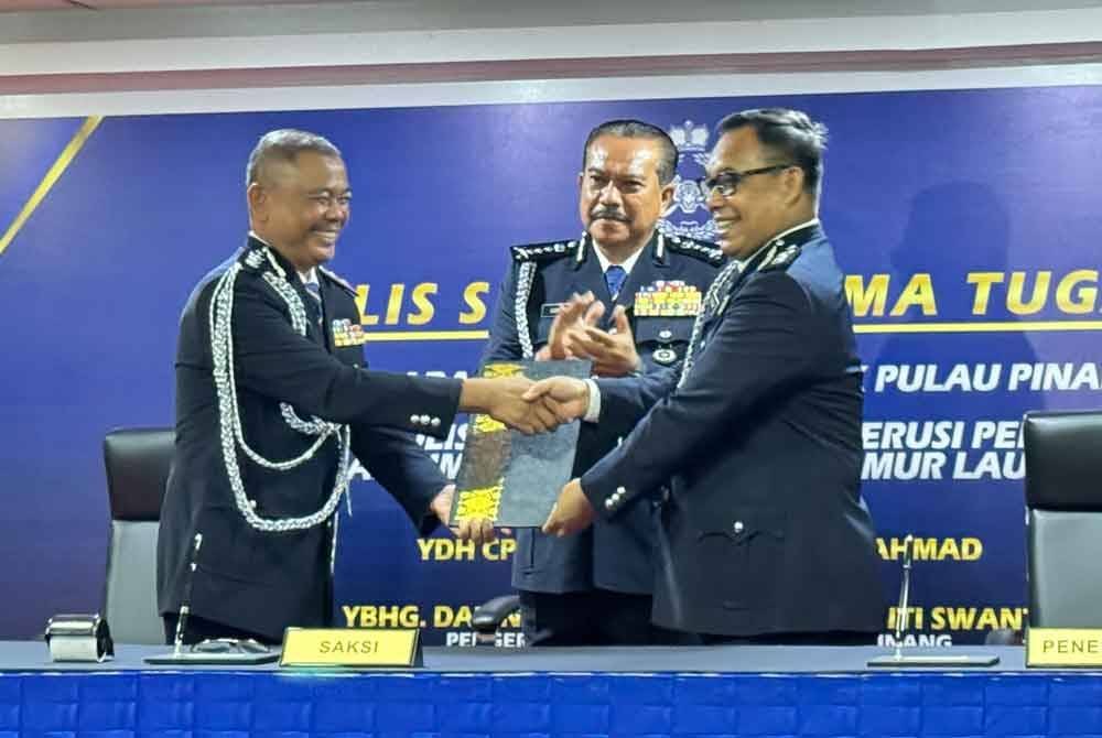 Hamzah (tengah) menyaksikan majlis serah terima tugas antara Asisten Komisioner Muhammad Halim Yatim (kiri) dan Asisten Komisioner Razlam Ab Hamid (kanan) di IPD Timur Laut pada Isnin.