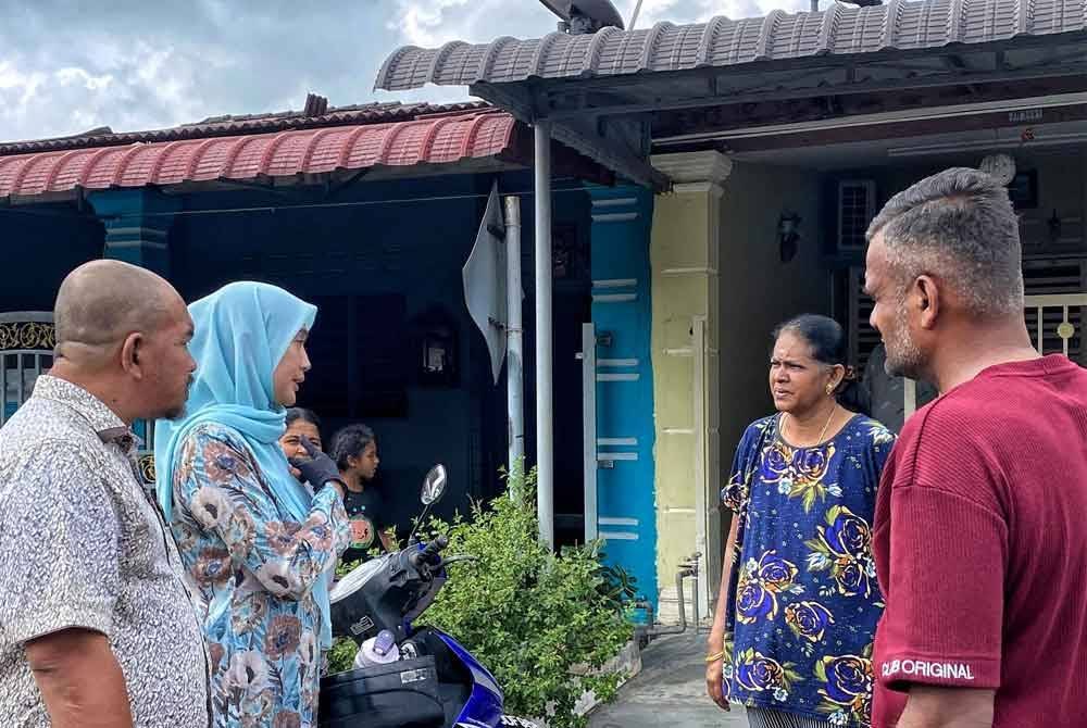 Khaidhirah (dua dari kiri) ketika bertemu penduduk yang terjejas di Taman Kelubi Damai pada Isnin.