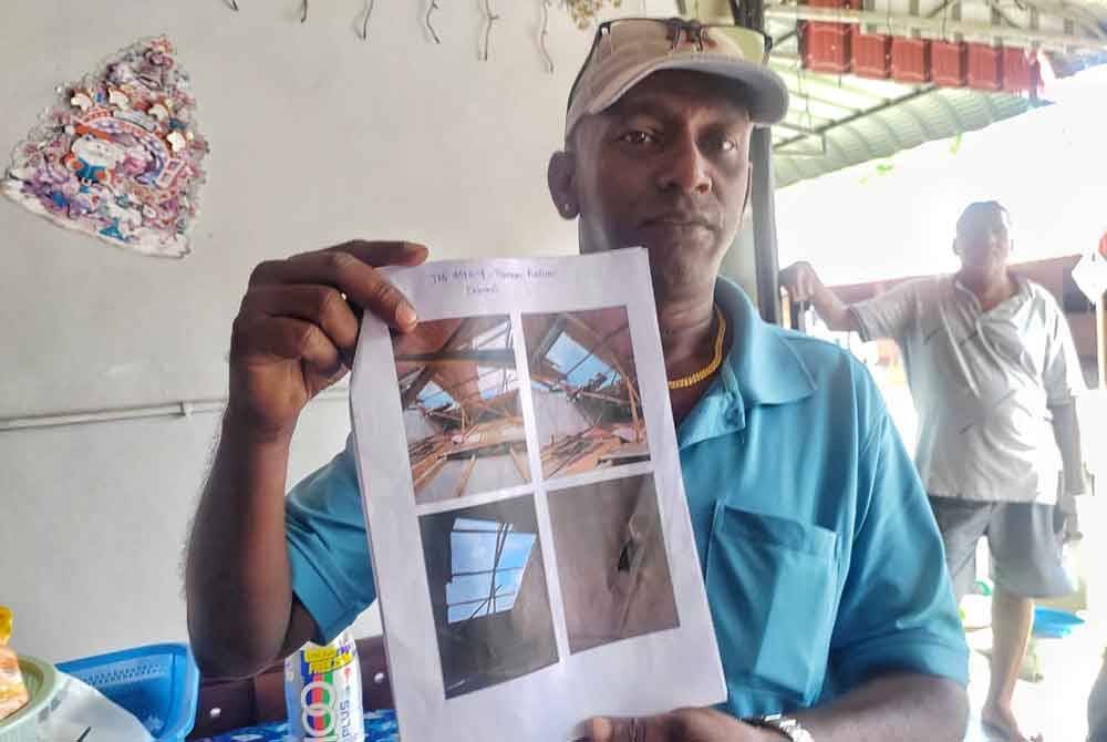 Nelson menunjukkan gambar rumahnya yang mengalami kerosakan bumbung akibat bencana ribut yang berlaku pada petang Ahad.