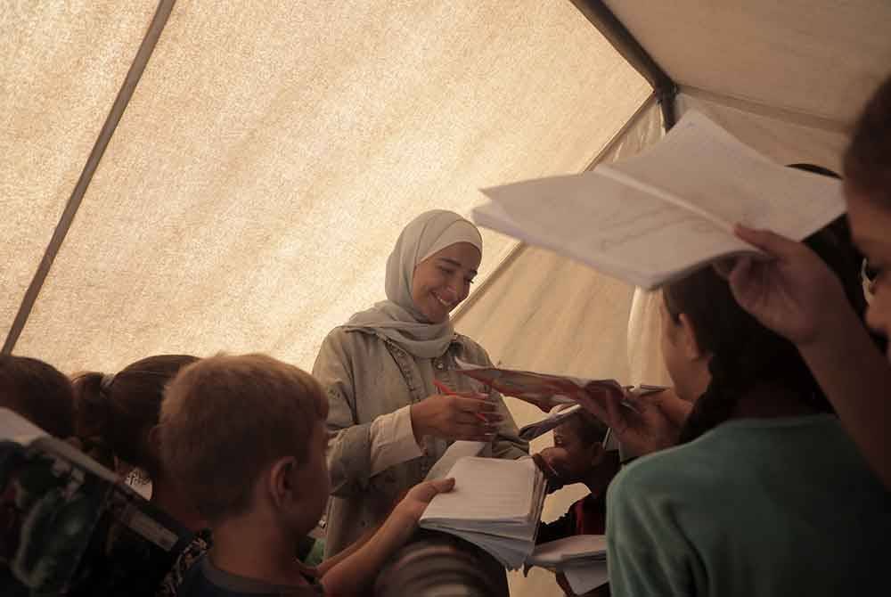 Pelajar Palestin menghadiri kelas di sekolah khemah yang didirikan di dalam pusat perpindahan di bandar Deir al-Balah. Foto Bernama