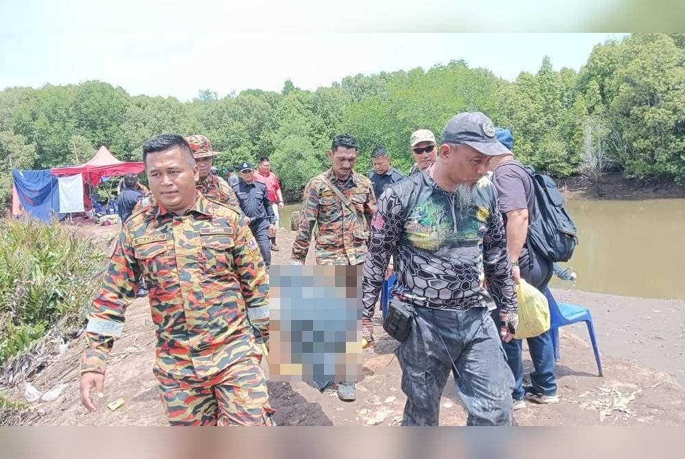 Mayat mangsa dibaham buaya dibawa naik ke darat oleh pasukan bomba sebelum diserahkan kepada pihak polis.