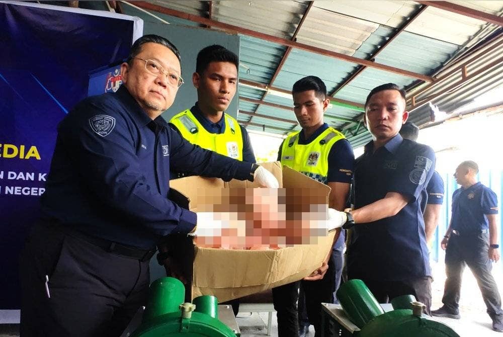 Nik Yusaimi (kiri) menunjukkan alat permainan seks yang akan dilupuskan.