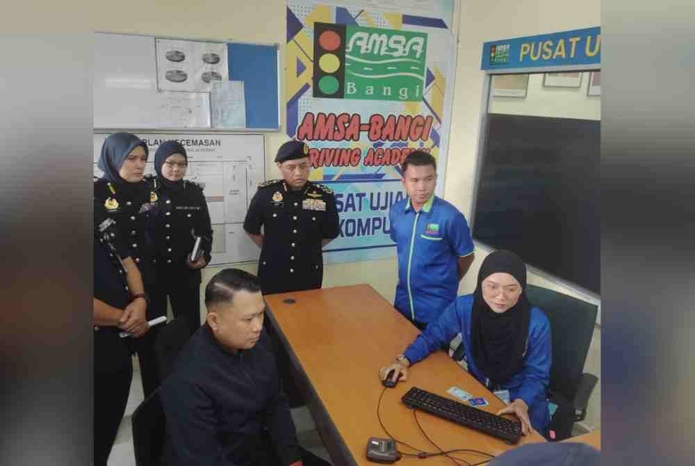 Aedy Fadly (tengah) ketika meninjau proses Program Khas Peralihan Lesen Memandu Malaysia (LMM) Kelas B2/B1 Kepada LMM Kelas B di sebuah institut memandu di Kajang pada Selasa.