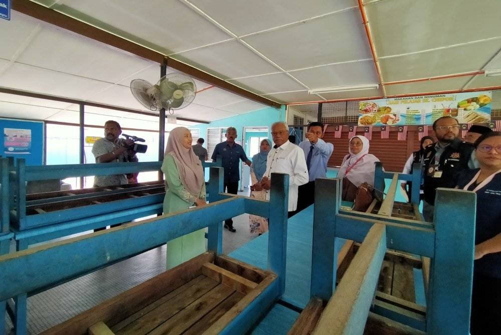 Sivanesan (dua dari kiri) ketika meninjau keadaan kantin SK Chepor yang diarah tutup selama 14 hari susulan kes keracunan makanan di sekolah tersebut.