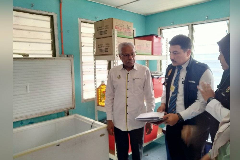 Sivanesan (kiri) mendengar taklimat daripada Jabatan Kesihatan ketika meninjau keadaan kantin SK Chepor pada Selasa.