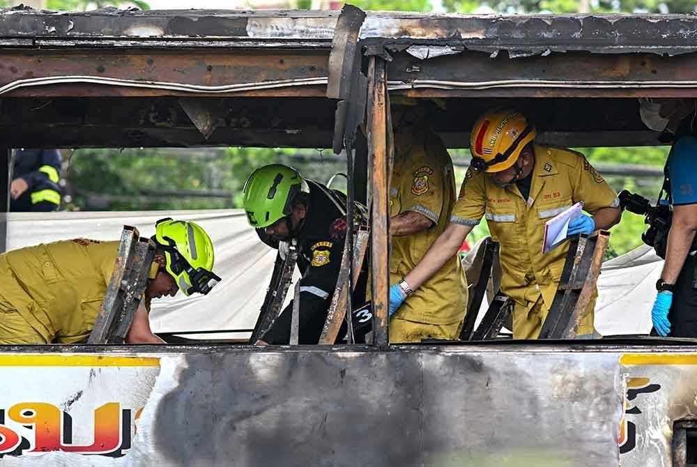 Anggota penyelamat memeriksa bas yang terbakar yang membawa pelajar dan guru di pinggir Bangkok pada Selasa. Foto AFP