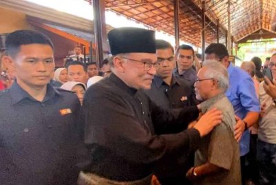 Anwar (dua dari kiri) ketika beramah mesra dengan pengunjung semasa Majlis Ramah Mesra Bersama Peniaga-peniaga Pasar Besar Siti Khadijah di Laman Siti Khadijah pada Selasa.
