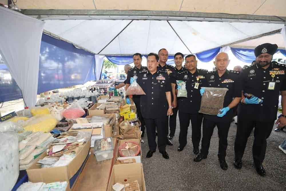 Rusdi (kiri) menunjukkan barangan kes yang akan dilupuskan.