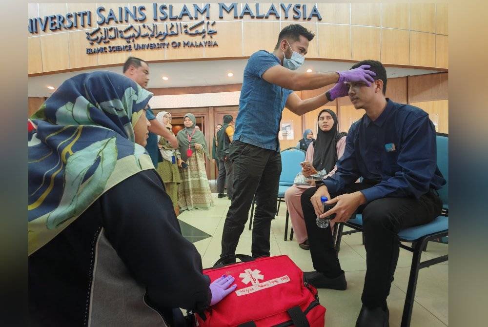 Pegawai perubatan USIM memeriksa kepala Hariz yang terhantuk akibat kemalangan berlaku.
