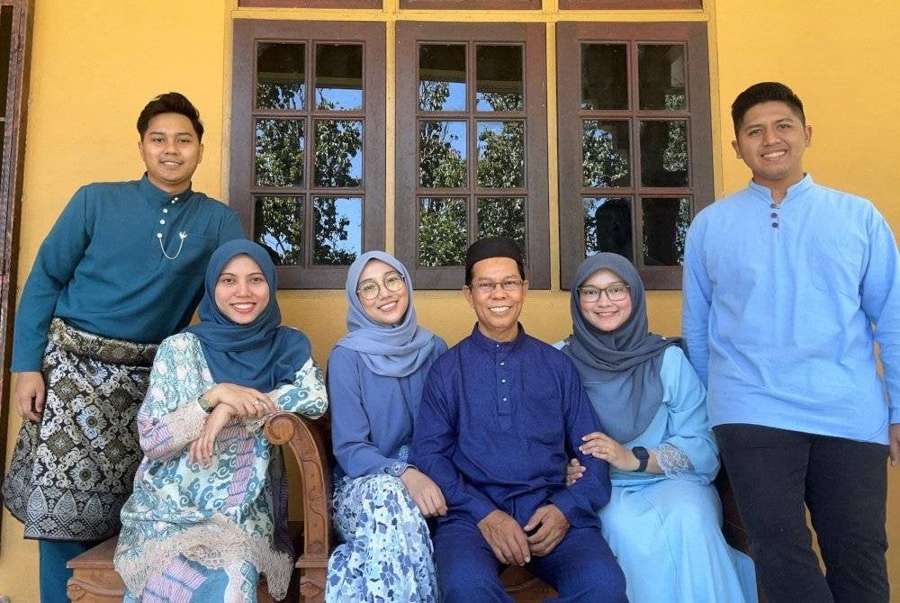 Gambar kenangan Sabari (duduk, tengah) bersama anak dan menantu.
