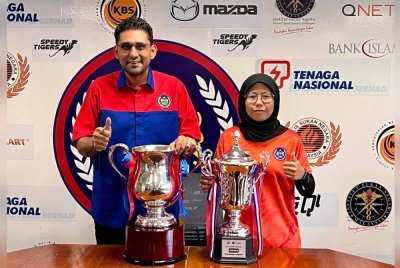 Anil (kiri) bersama Norakma menunjukkan trofi buat juara Piala Tun Abdul Razak. Foto MHC