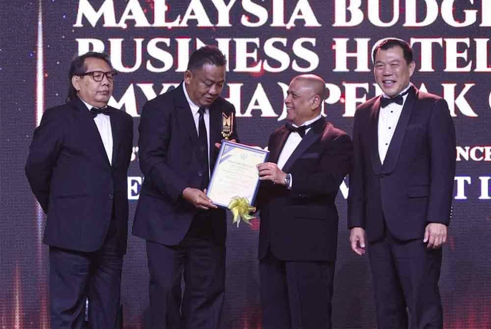 Pengerusi Persatuan Hotel Budget Malaysia (MyBHA) Perak, Zamari Muhyi (dua dari kiri) menerima trofi dan sijil bagi kategori Lifetime Achievement in Tourism daripada Saarani.