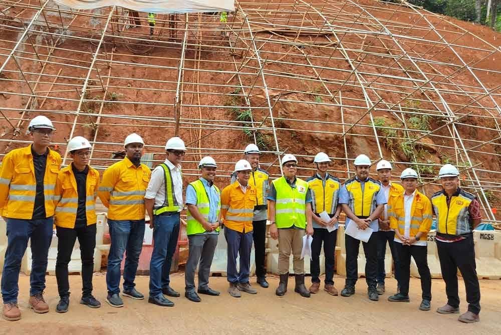 Izham (enam dari kanan) lokasi pengukuhan cerun di Jalan Genting Peras pada Khamis.