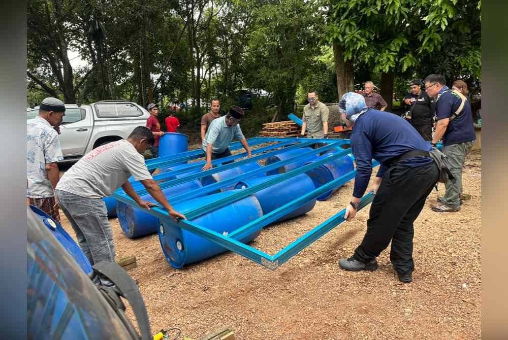 Kerja-kerja pembinaan rakit yang disertai penduduk di Tersang, Rantau Panjang.