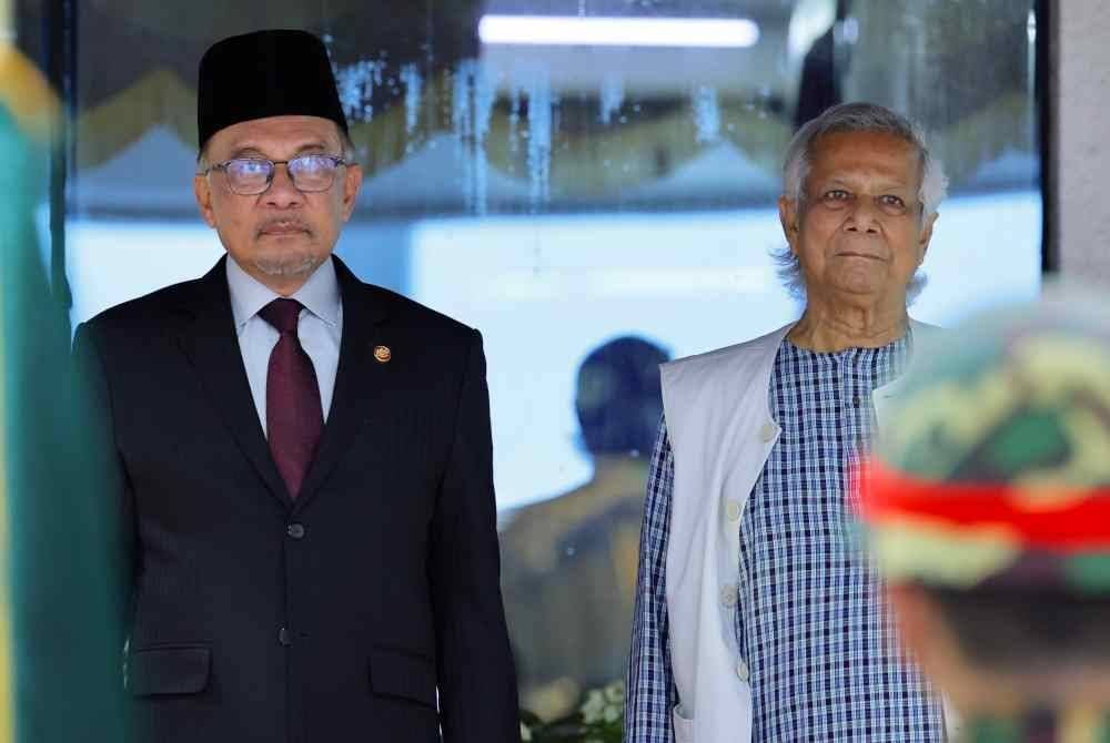 Anwar (kiri) disambut oleh Dr Muhammad Yunus ketika tiba di Lapangan Terbang Antarabangsa Hazrat Shahjalal sempena lawatan rasmi ke Bangladesh pada Jumaat. Foto Bernama