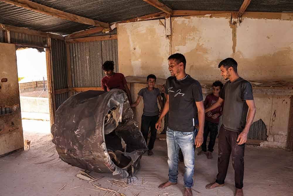 Orang ramai melihat sisa peluru berpandu Iran yang jatuh di kawasan padang pasir Negev berhampiran Arad.