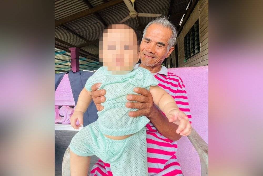 Rakaman gambar musa ketika memegang cucunya pada September lalu. Gambar Ihsan Keluarga