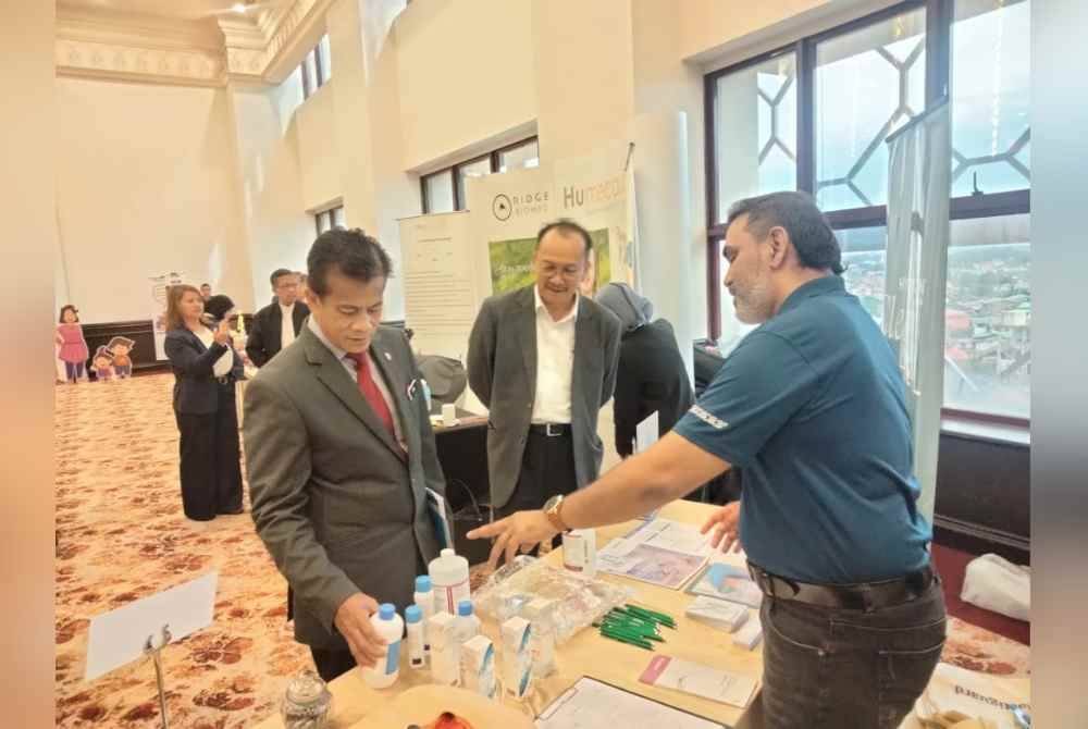 Dr Zaini (kiri) mendengar maklumat mengenai pencuci luka selepas merasmikan Seminar 'Burn Talk, Back to Basic: Rivitalizing Core Competencies in Burn Management' di sini pada Sabtu.