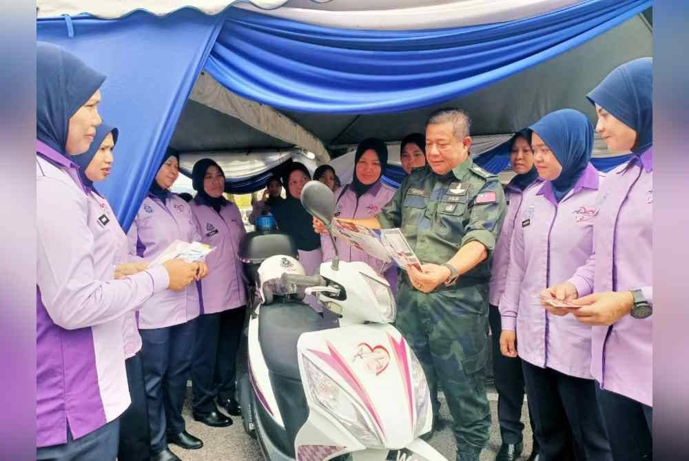 Azizi bersama Skuad Amanita ketika meninjau pameran disediakan sempena perasmian Taman Angkat Amanita Perak di Dewan Konvensyen Pusing, Batu Gajah pada Sabtu.