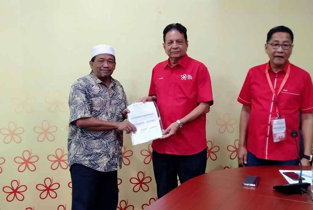 Mahader Ahmad (tengah) menyerahkan senarai nama calon yang layak bertanding pada pemilihan kali ini kepada wakil-wakil bahagian Bersatu Perak di Pejabat Bersatu Perak di sini pada Sabtu.