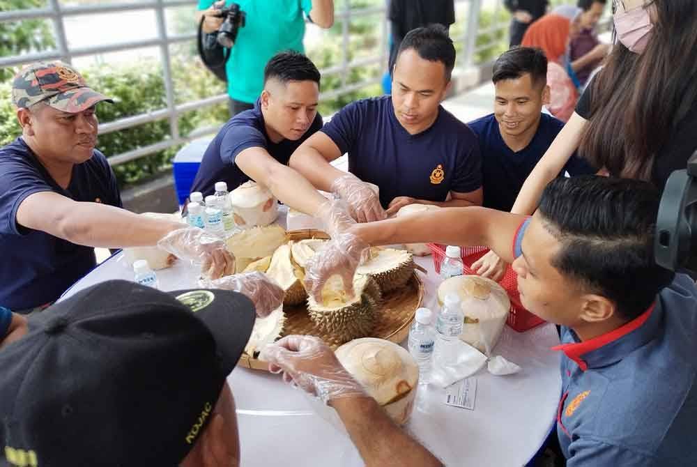 Petugas bomba turut menikmati buah durian.