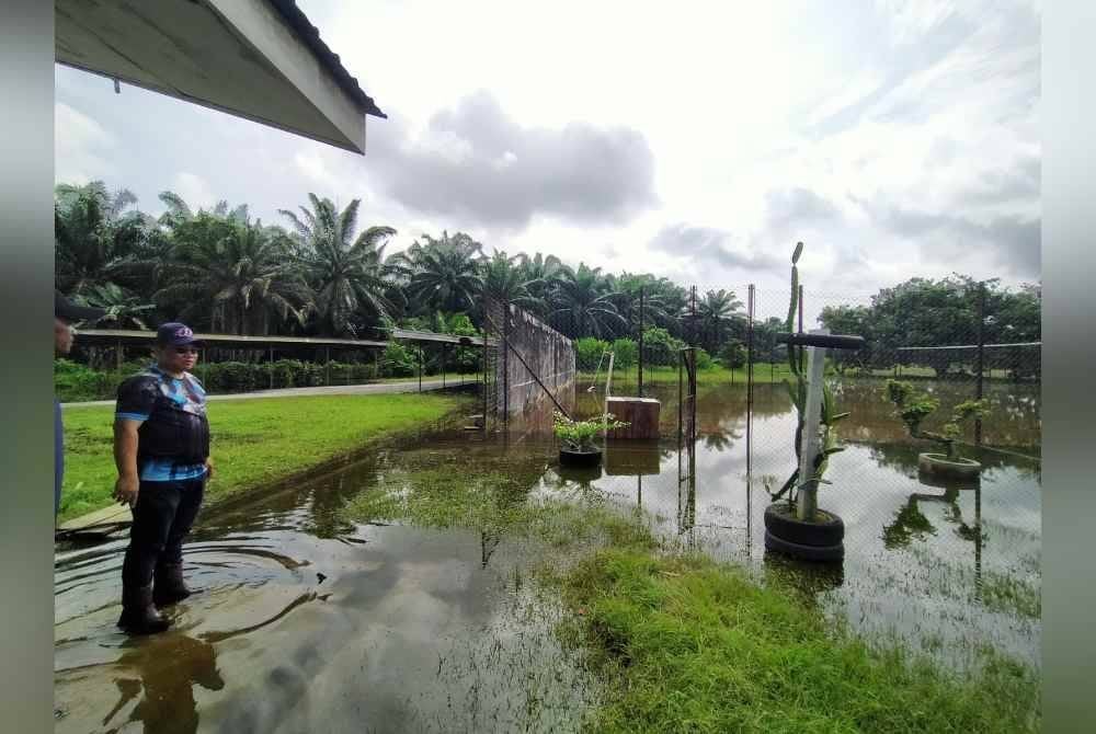 Megat Mahmud menunjukkan gelanggang bola tampar serta kawasan parkir motosikal pelajar yang dinaiki air akibat banjir.