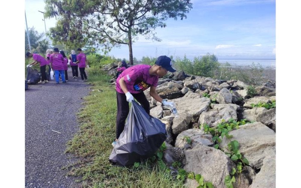 Sukarelawan sedang mengutip sampah di persisiran pantai Kurong Tegar di Kuala Perlis, pada Ahad.