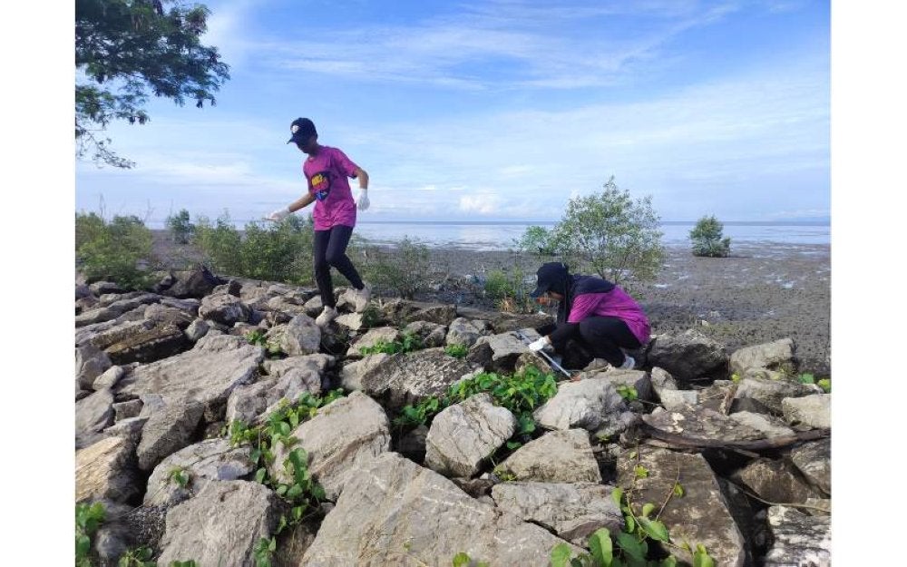 Sukarelawan yang mengambil bahagian turut sama mencari sampah di celahan batu.